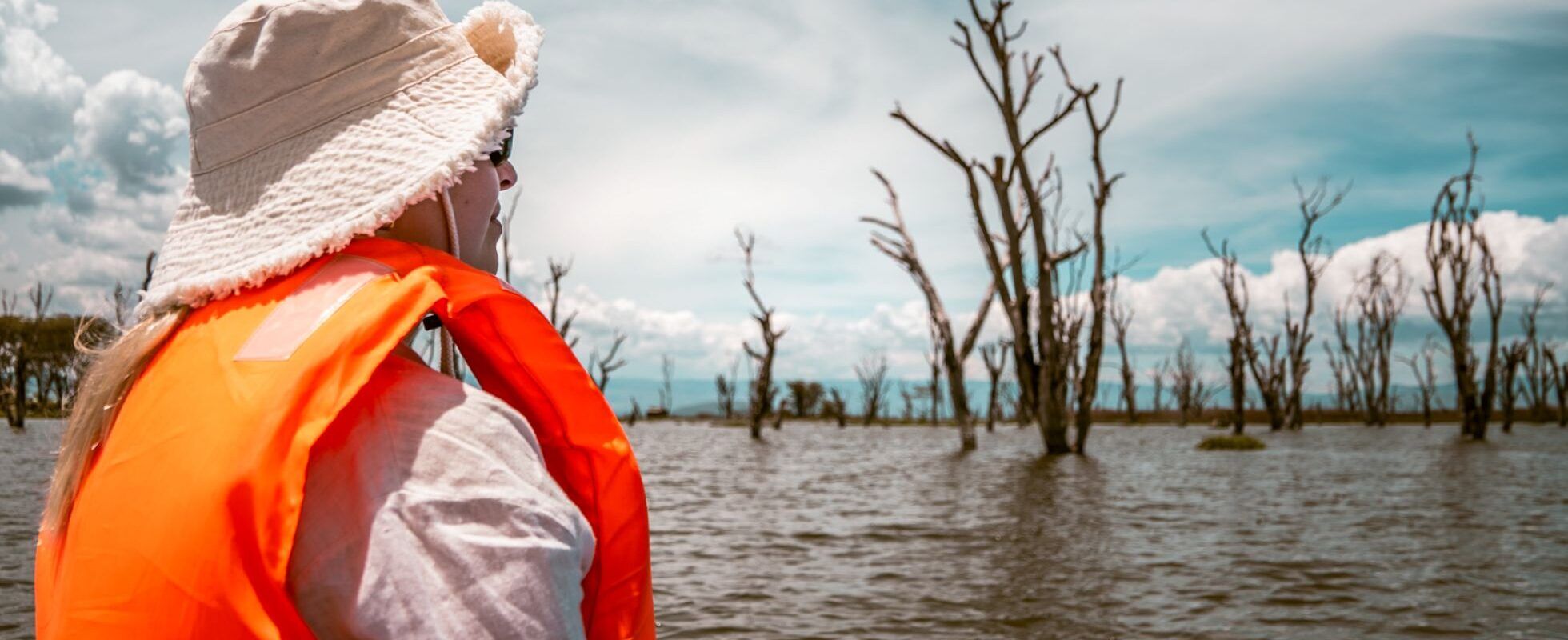 Un voyage au Kenya, ou l'aventure ultime. Une femme observe une girafe dans la savane avec des jumelles.